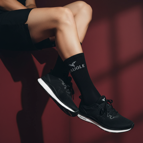 Person sitting wearing black Daugle socks burgundy background